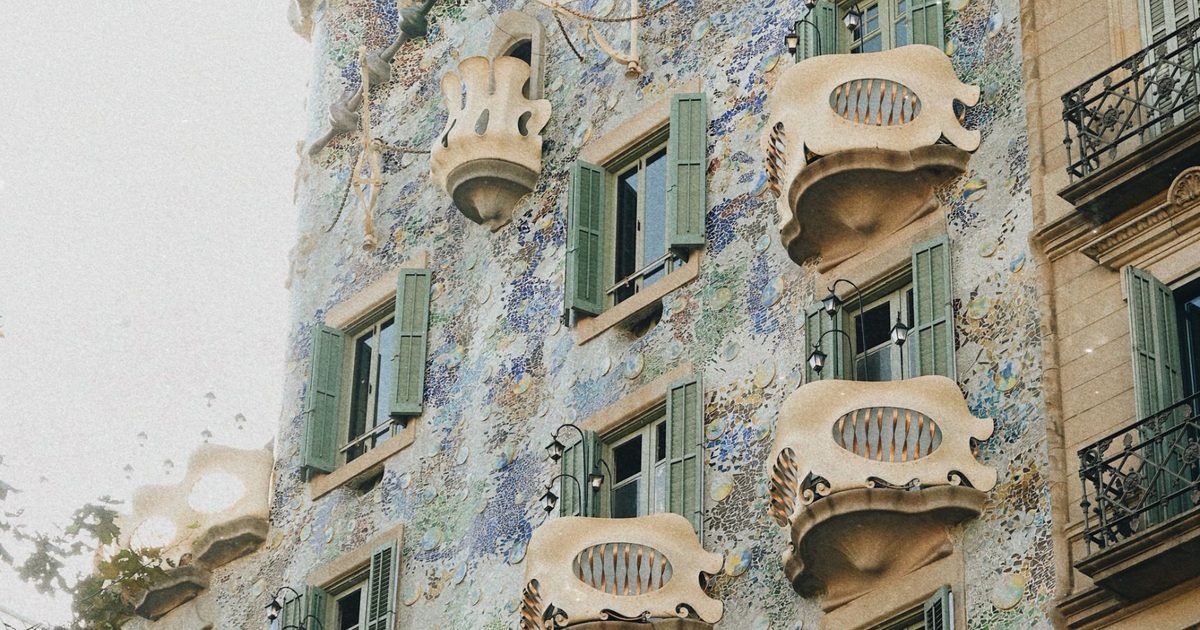Fachada modernista con balcones de piedra y mosaico de colores en el centro de Barcelona