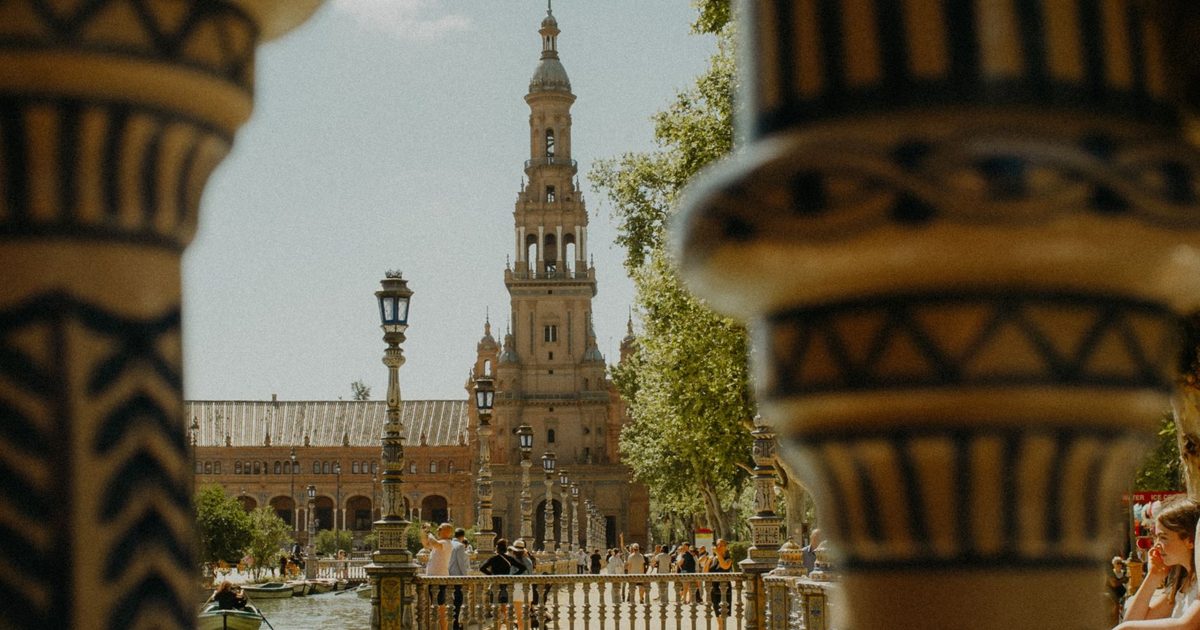Torre de la Plaza de España de Sevilla vista entre columnas de cerámica azul y blanca